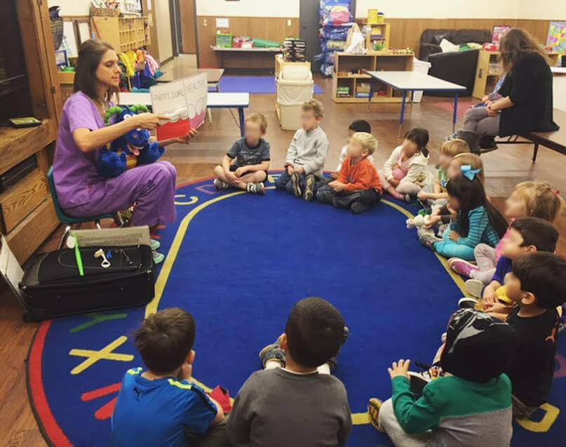 A group of children sitting in a circle learning about dentistry in a pediatric office
